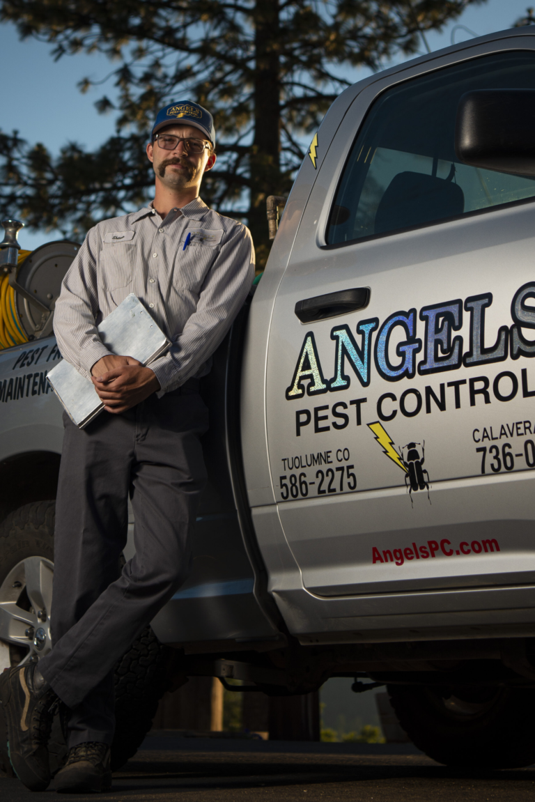 A Man Leaning on a Pest Control Truck